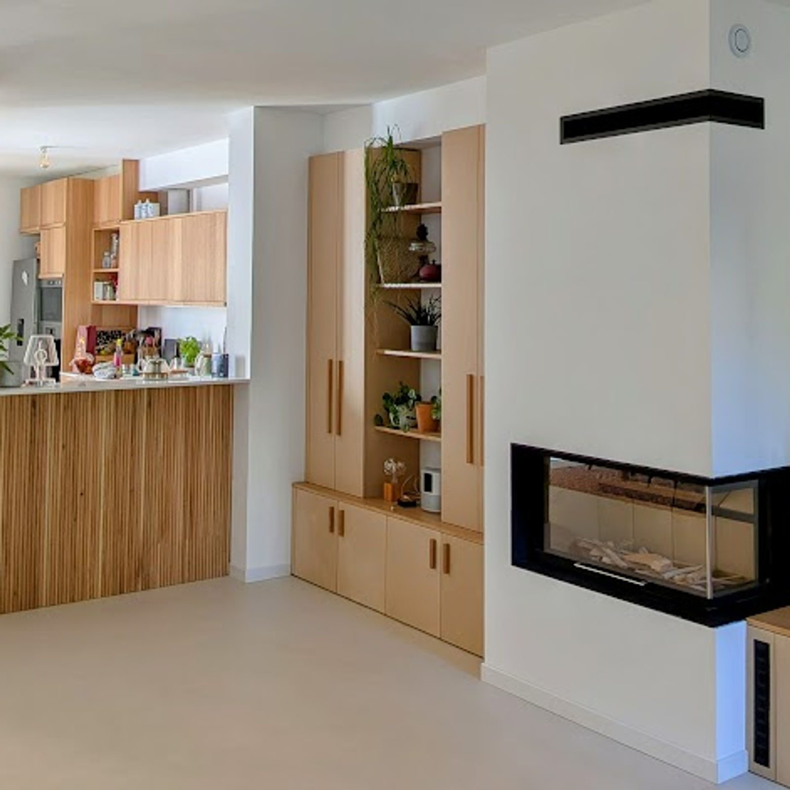 Cuisine et rangements intégrés en bois clair, photographiés dans un intérieur.