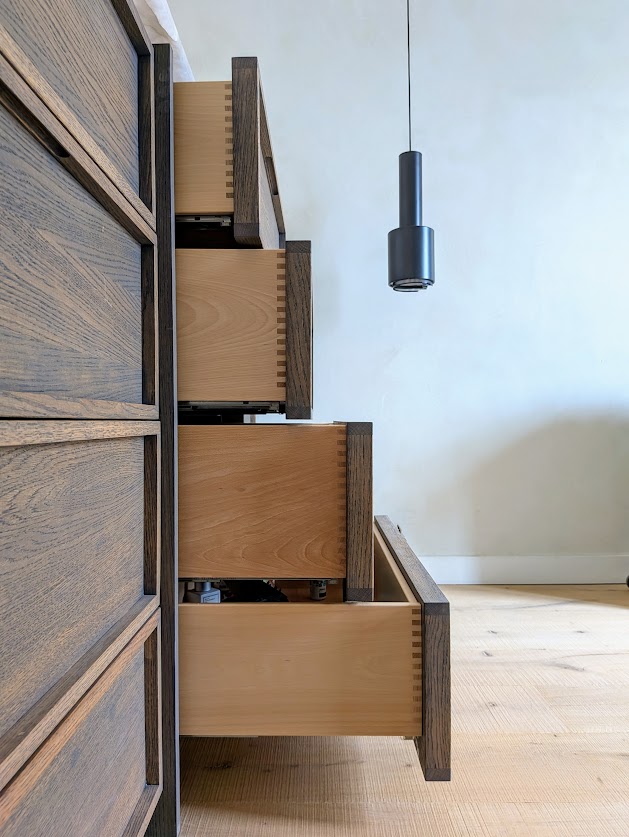 Tiroirs ouverts montrant leurs assemblages et façades en bois.
